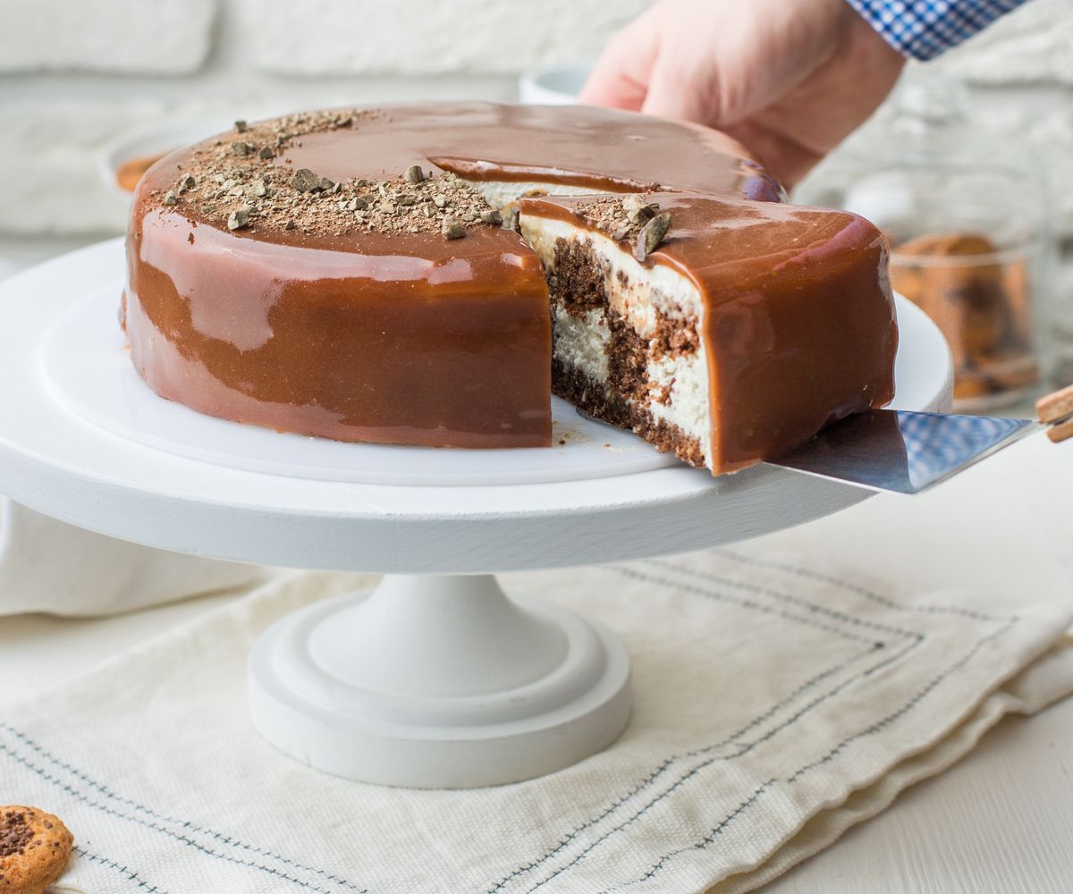 Chocolate-glazed layer cake on a cake stand