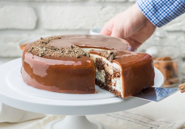 Chocolate-glazed layer cake on a cake stand
