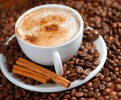 A cup of cappuccino on coffee beans