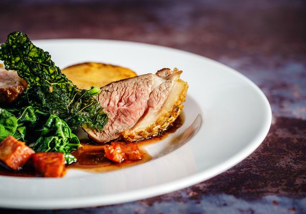 Roast meat with greens on a white plate
